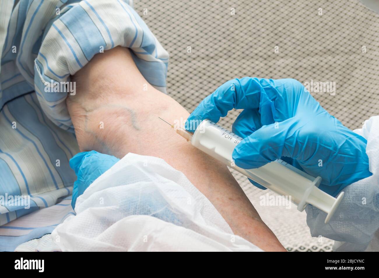 Medical worker makes blood from a potentially infected elderly woman for checking test to covid 19. Medicine and healthcare concept. Stock Photo