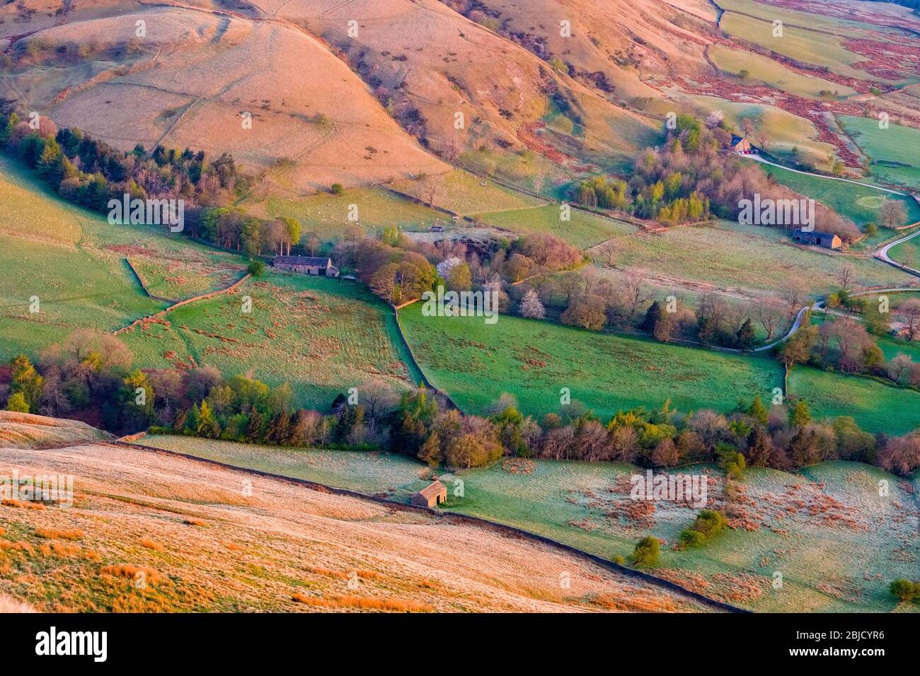 Hillsides and fields lit by early morning sun,  from Rushup Edge at dawn. Peak District National Park, UK Stock Photo