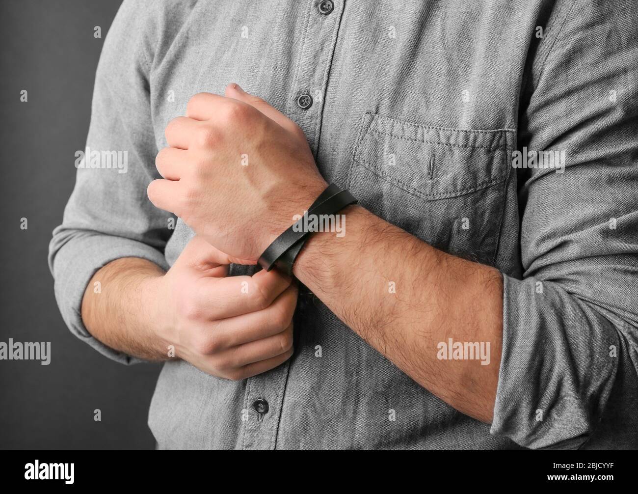 Closeup of man with stylish leather bracelet on dark background Stock Photo  - Alamy