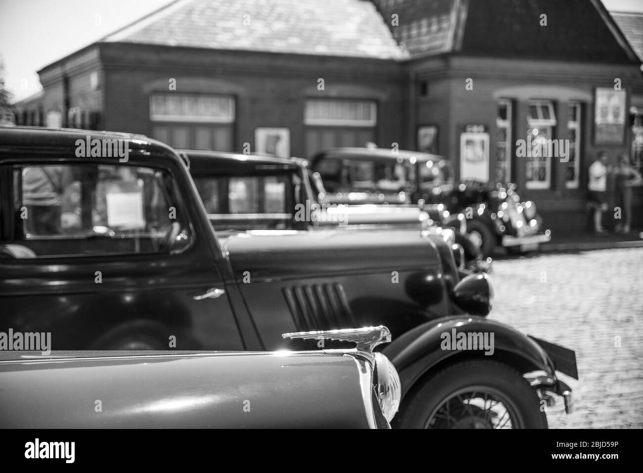 Monochrome side view of 1940s vintage classic motor cars parked in summer sunshine, Severn Valley Railway Kidderminster heritage railway station, UK. Stock Photo