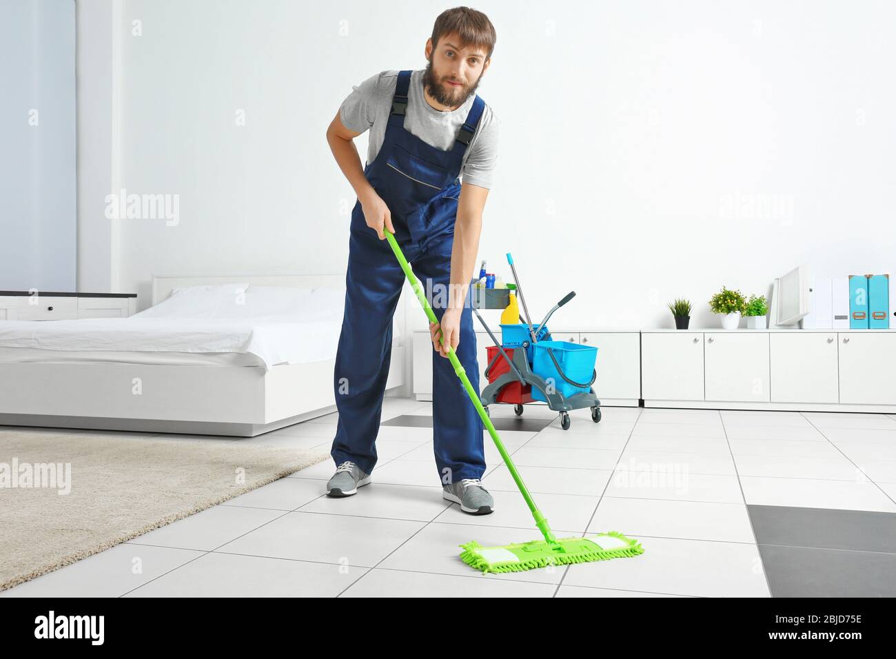 Funny young man moping floor at home Stock Photo Alamy