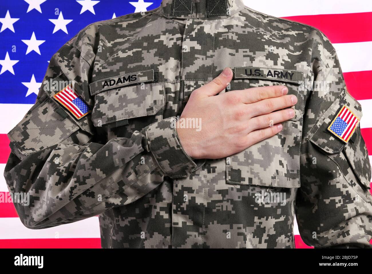 Soldier with hand on heart against USA flag Stock Photo - Alamy