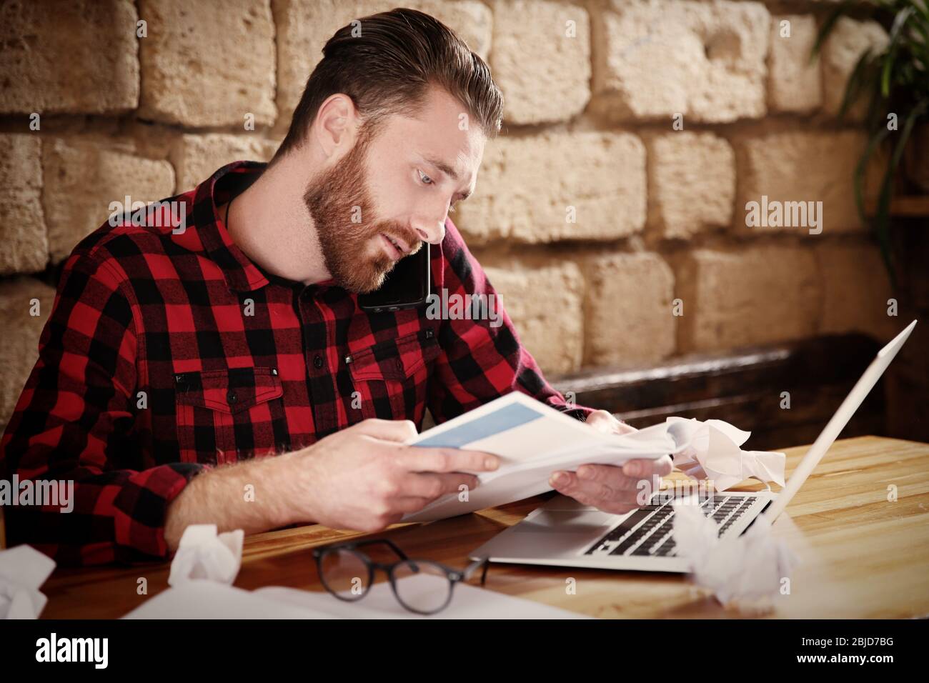 Handsome young man working on computer at cafe Stock Photo