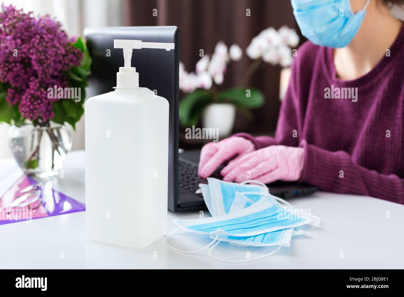 Woman working or learning from home with laptop during Coronavirus, Covid-19 quarantine wearing medical protective mask.Freelancer Remote work Stock Photo