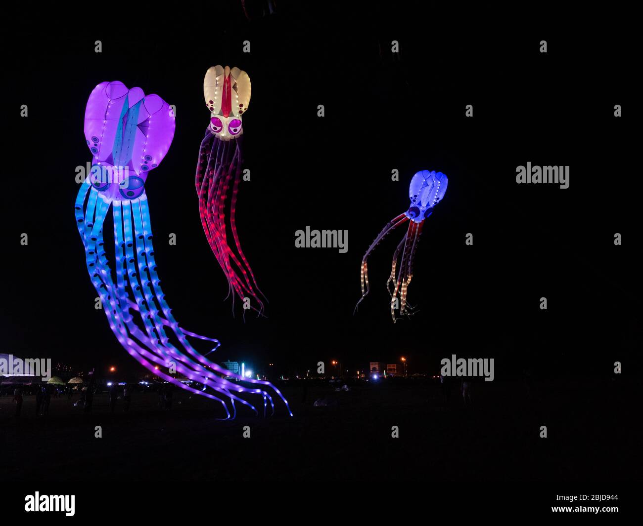 Satun, Thailand - February 22, 2020: Three giant soft kites illuminated by LED lights and shaped as octopuses flying at night during Satun Internation Stock Photo