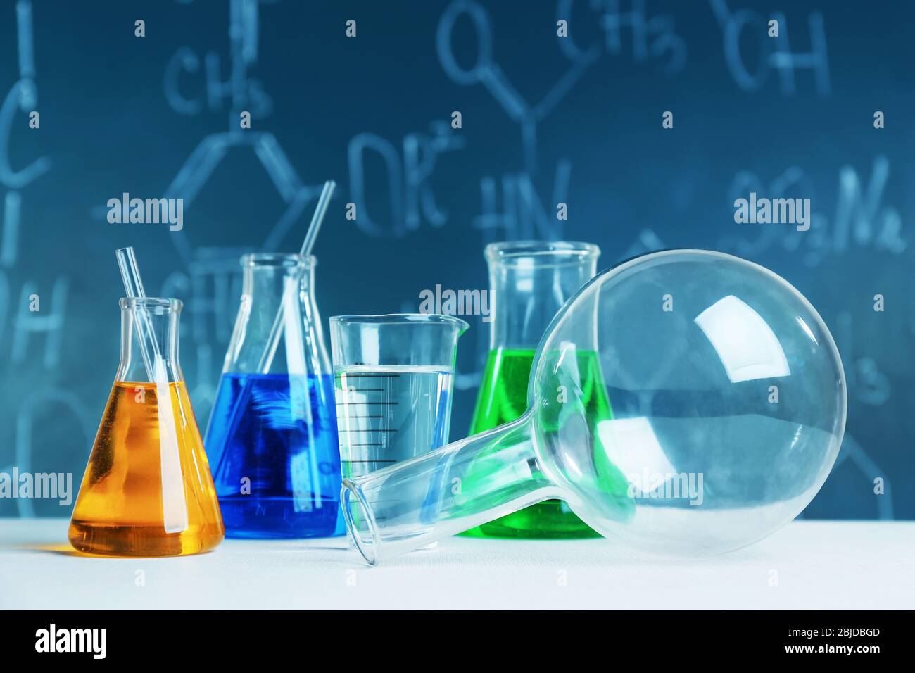 Test beakers and flasks on blackboard background Stock Photo - Alamy