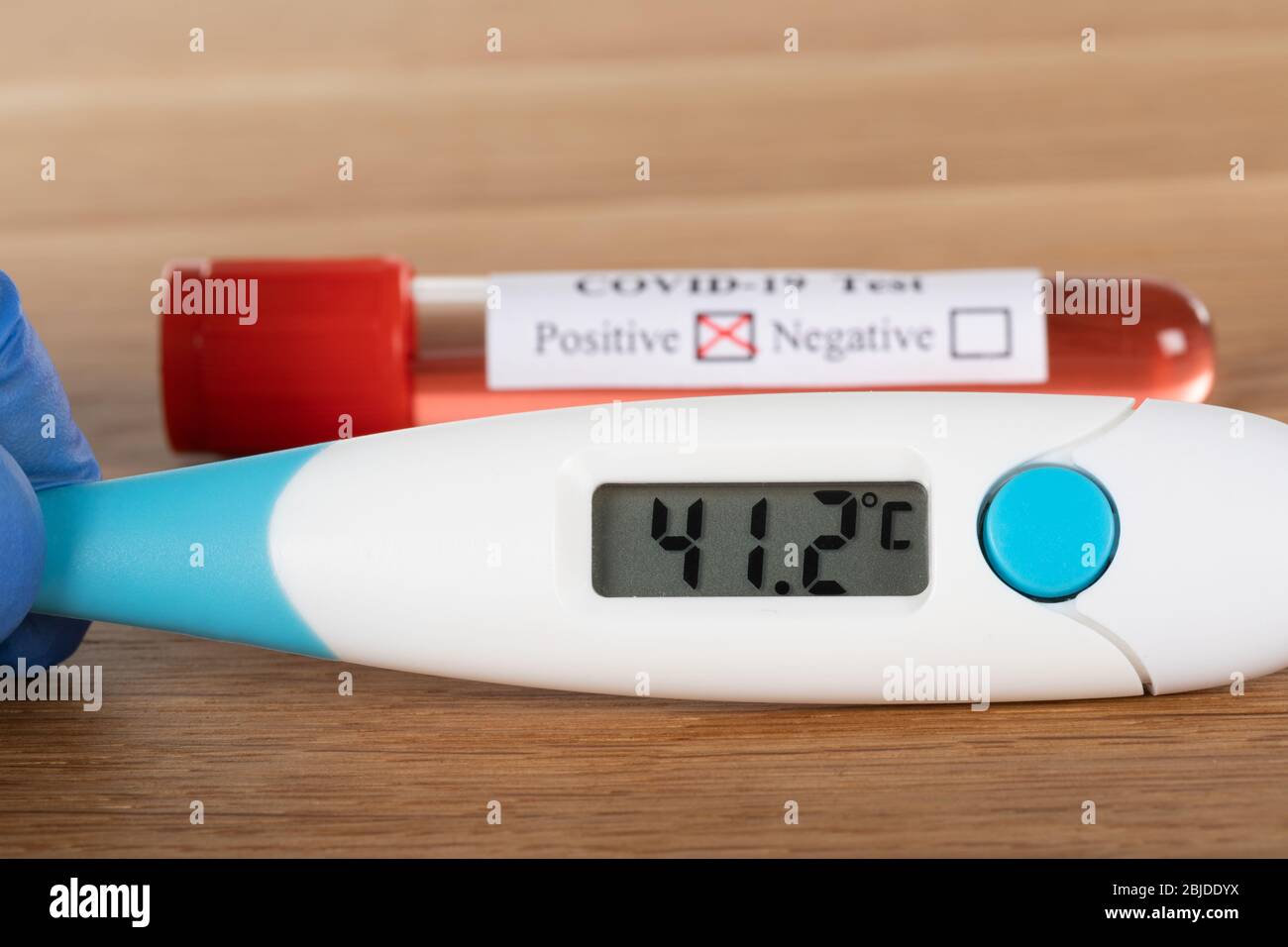 Covid-19 test sample and digital thermometer on wooden background Stock Photo - Alamy