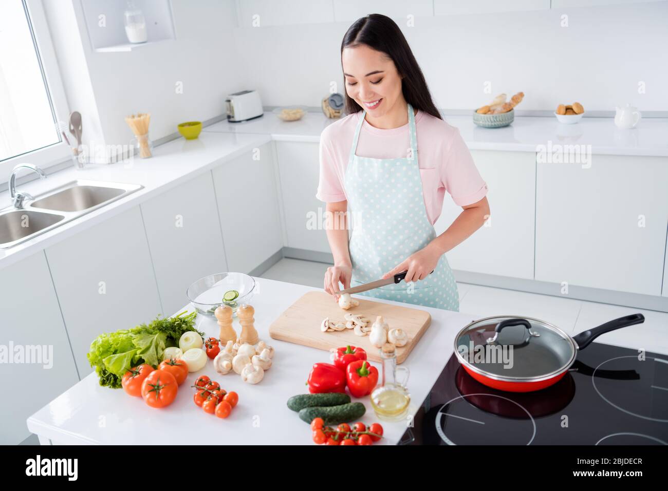 Photo of beautiful asian ethnicity housewife hold knife cut down fresh mushrooms weekend cooking tasty breakfast salad vegan concept stand good mood Stock Photo