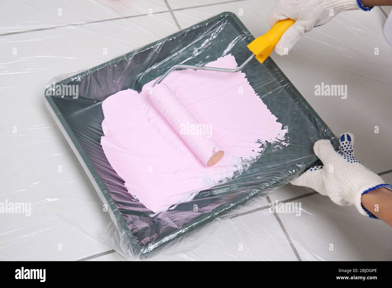 Worker using paint roller and tray while making repair, closeup Stock Photo