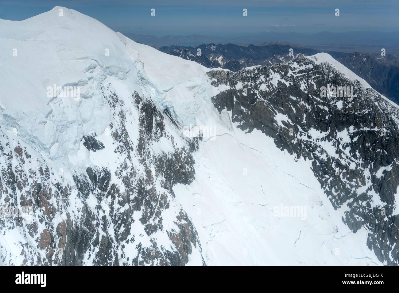 aerial, from a glider, with rocky cliffs and snow landslides at Mt ...