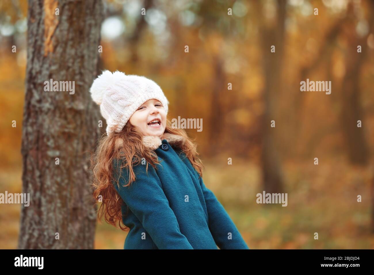 Cute little girl in autumn park Stock Photo - Alamy