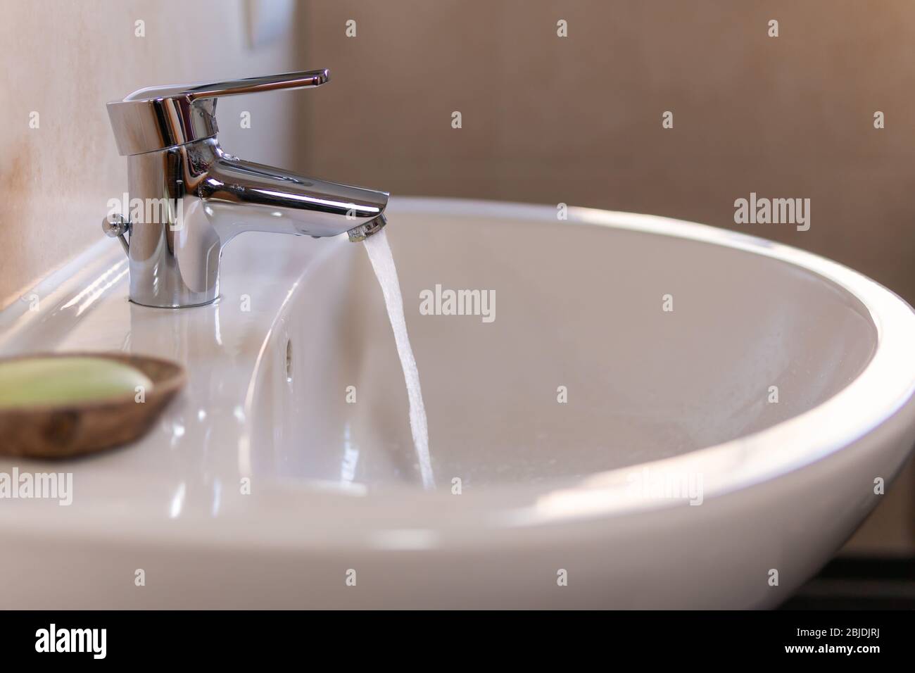 Running water tap spills water in wash basin. Concepts of cleaning,  hygiene, waste of money, saving money at utilities, economical usage of  water Stock Photo - Alamy