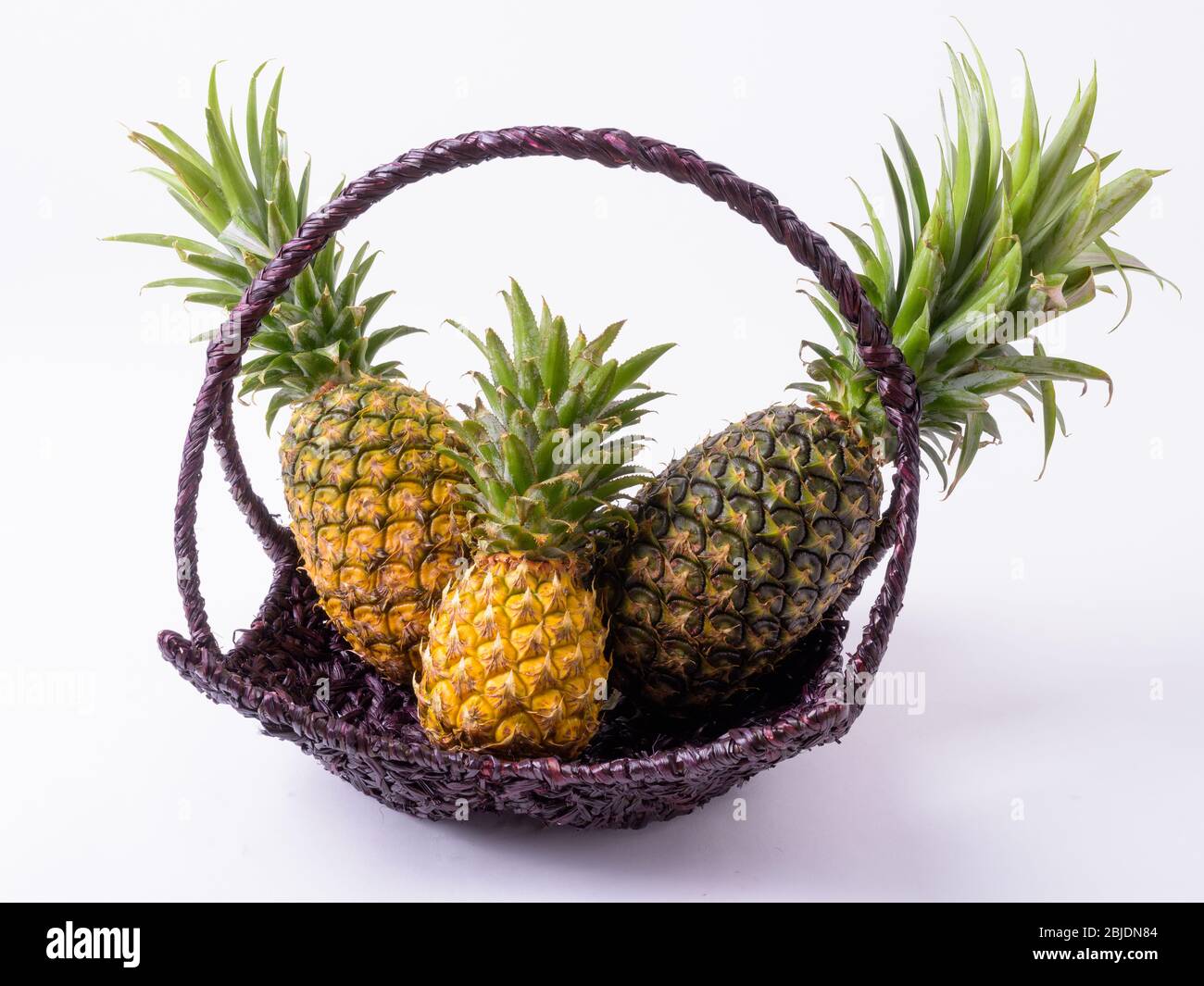 Portrait Of Basket With Delicious Ripe Pineapples Stock Photo