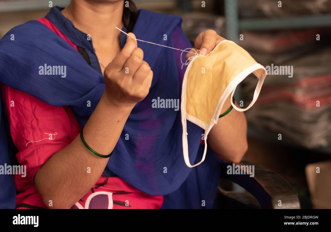 Girl hand Knitting DIY face mask at home to protect from covid-19 or coronavirus pandemic at India - Due to shortage of Medical masks woman in India Stock Photo