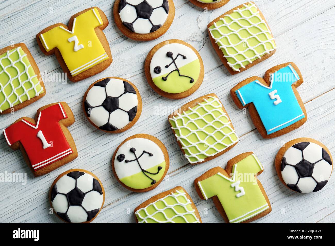 Delicious gingerbread cookies decorated with football signs on white wooden background Stock Photo