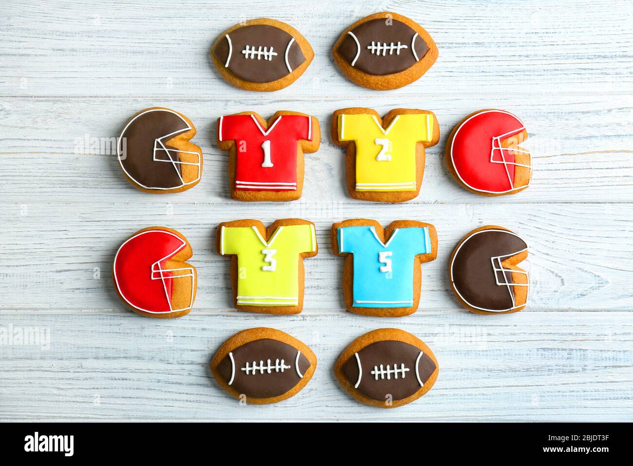Delicious gingerbread cookies decorated with football signs on white wooden background Stock Photo