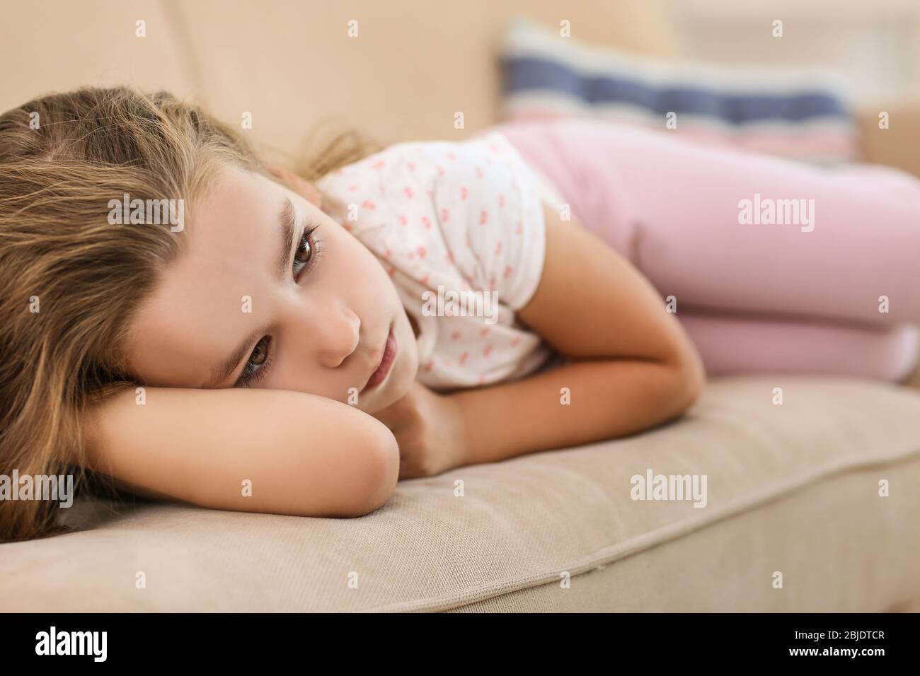 Sad little girl lying on sofa, closeup Stock Photo - Alamy