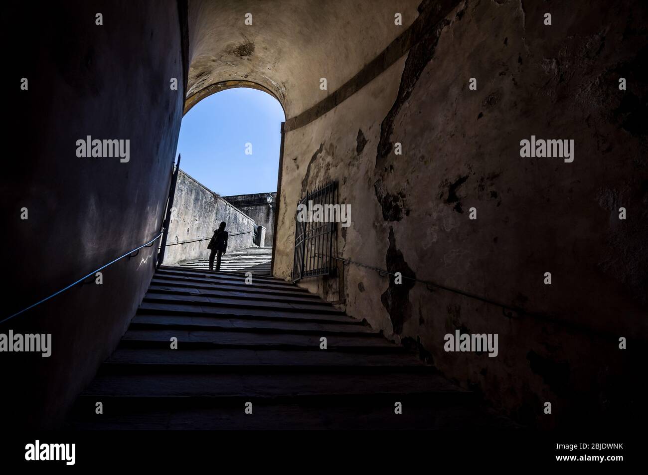 The girl at the end of the tunnel with stairway in Palazzo Pitti, Florence, Tuscany, Italy Stock Photo