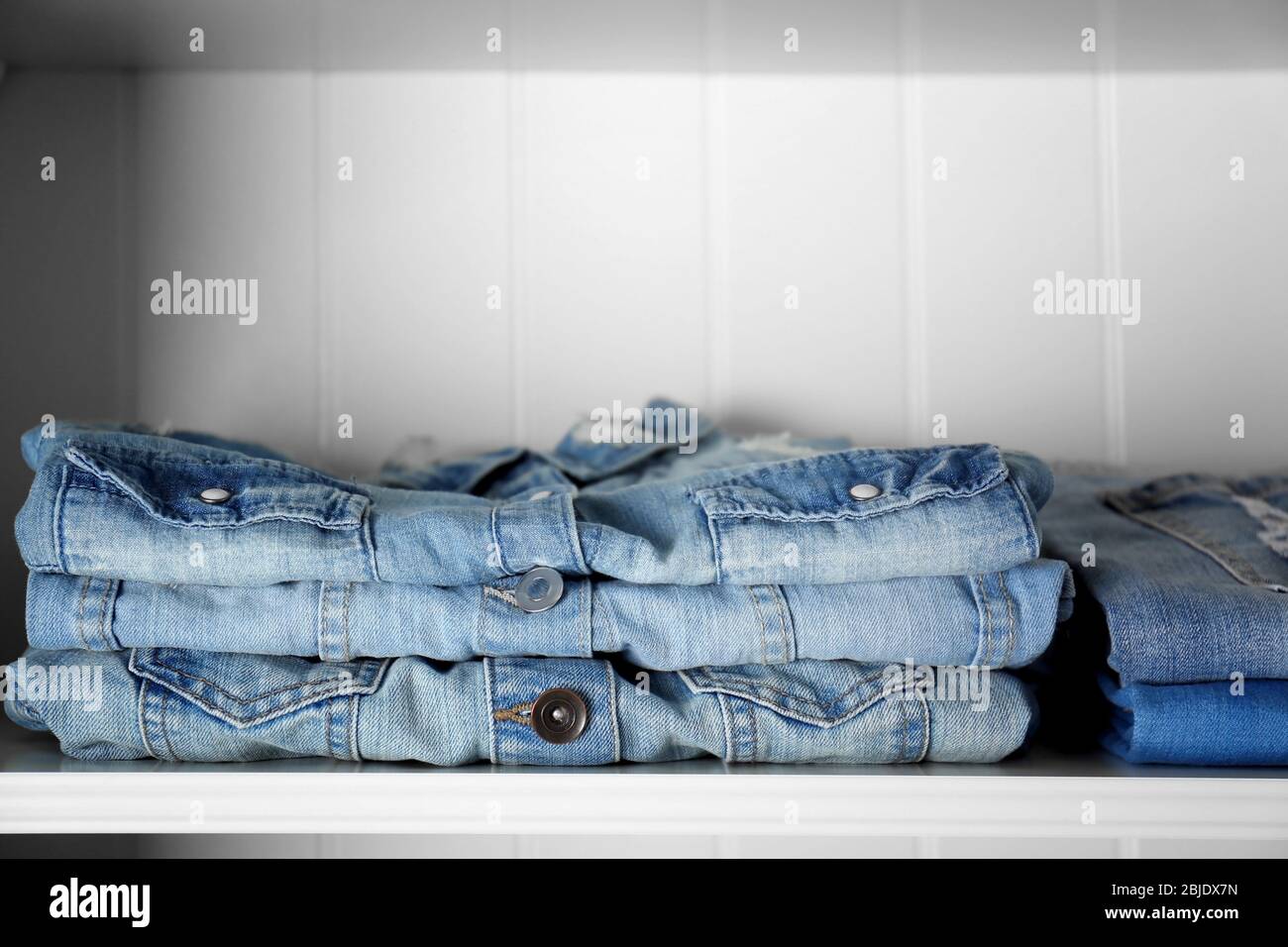 Stack of clothes on shelves Stock Photo Alamy