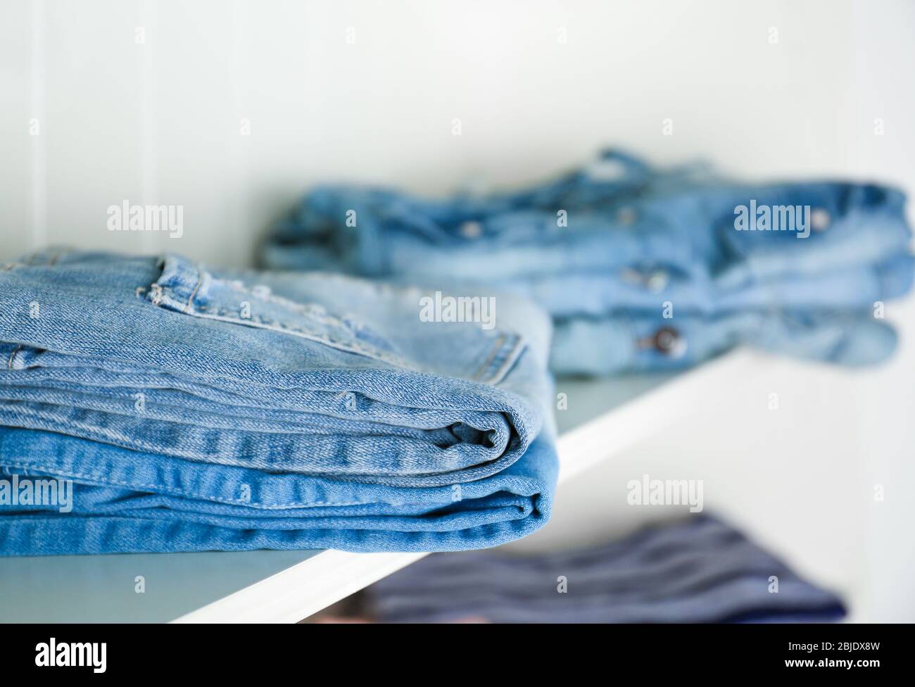 Stack of clothes on shelves Stock Photo Alamy