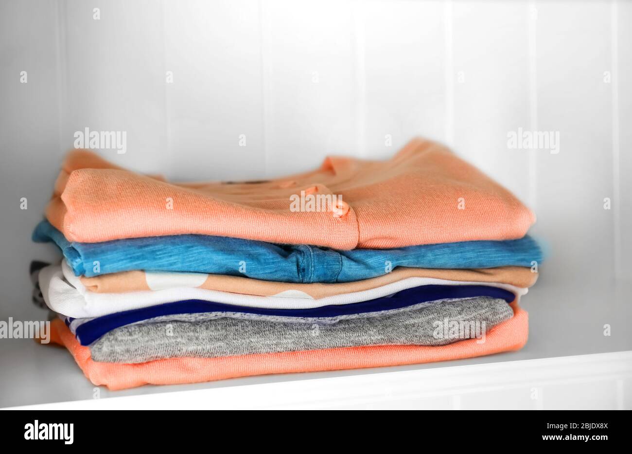 Stack of clothes on shelves Stock Photo - Alamy