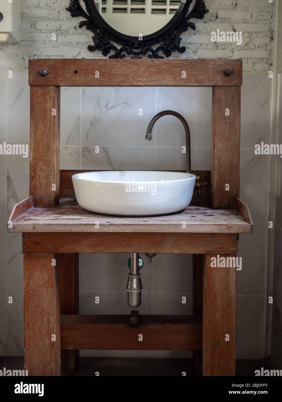 White Clean Ceramic Sink Bath And Faucet On Vintage Wooden Table