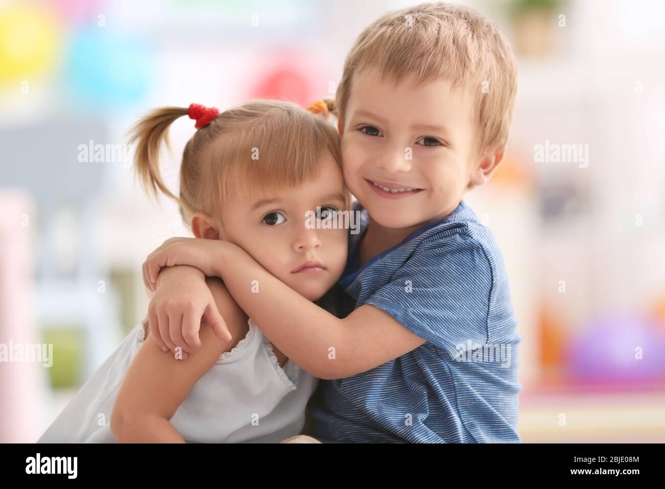 Cute little boy hugging sister at home Stock Photo Alamy