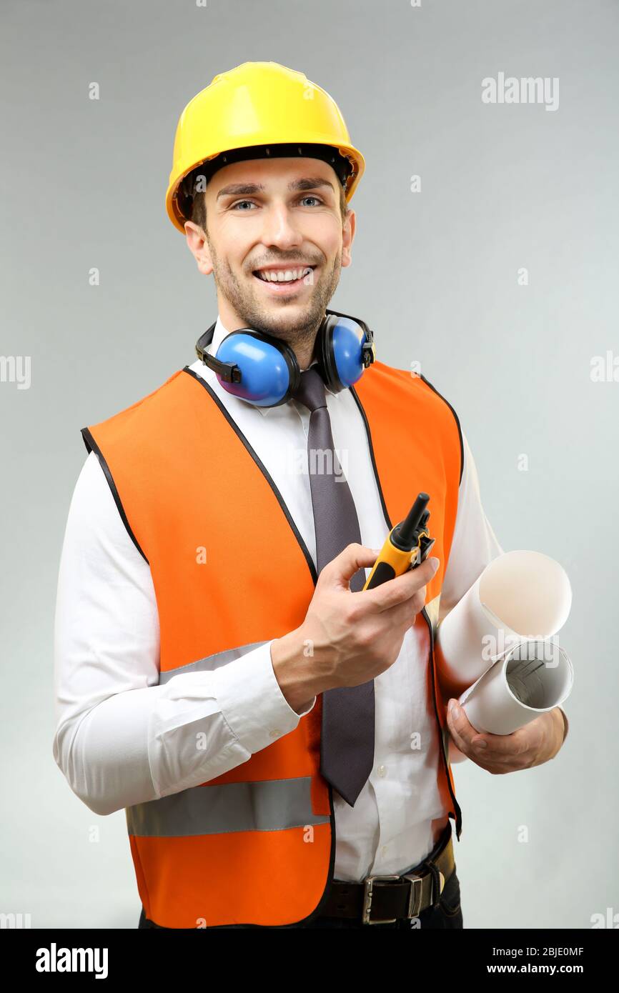 Hand Some Engineering Handsome engineer with portable radio transmitter and drawings on light ...