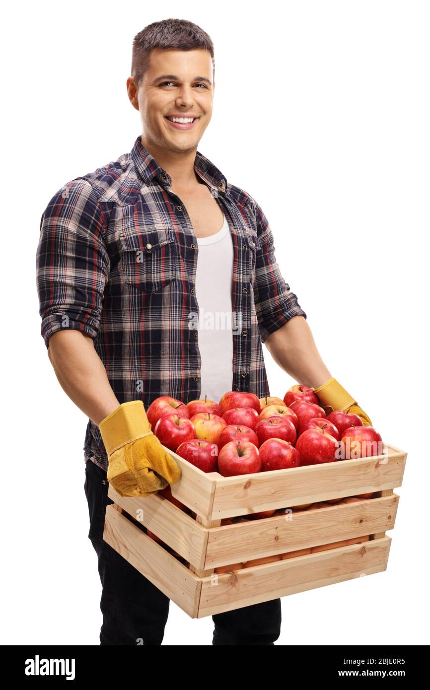 Young man holding a crate full of red apples isolated on white background Stock Photo