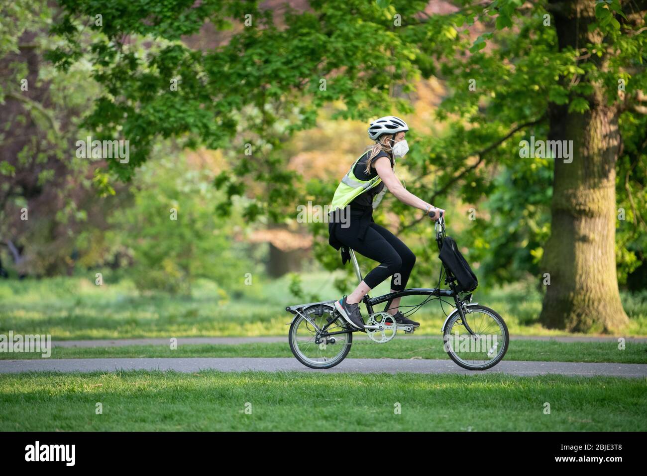 Woman cyclist wearing a face mask during the daily exercise in Lockdown. Stock Photo