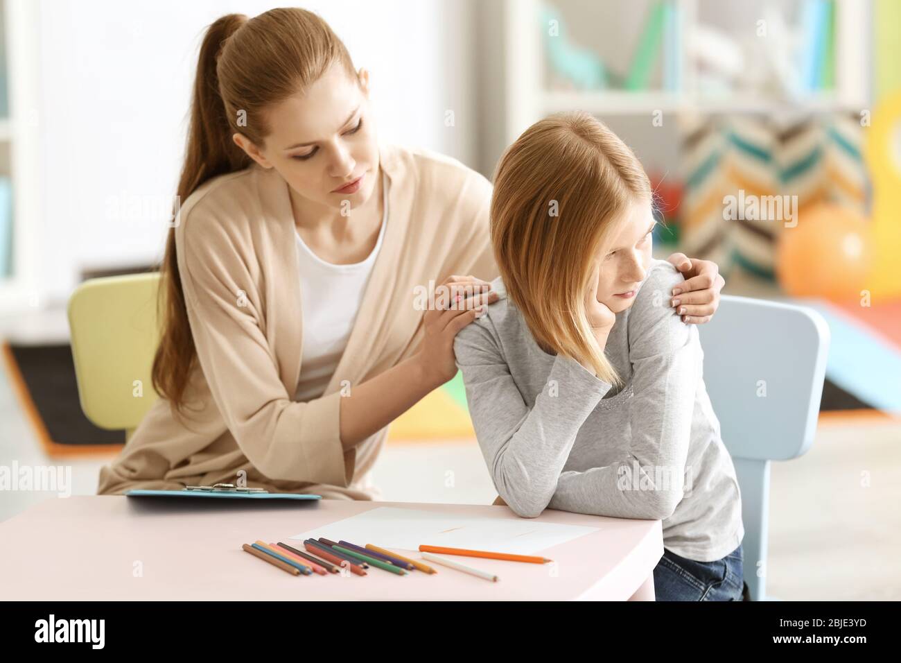 Young female psychologist working with teenager girl in office Stock