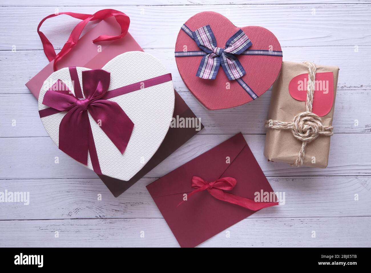 Different colorful gift boxes on wooden background. Stock Photo