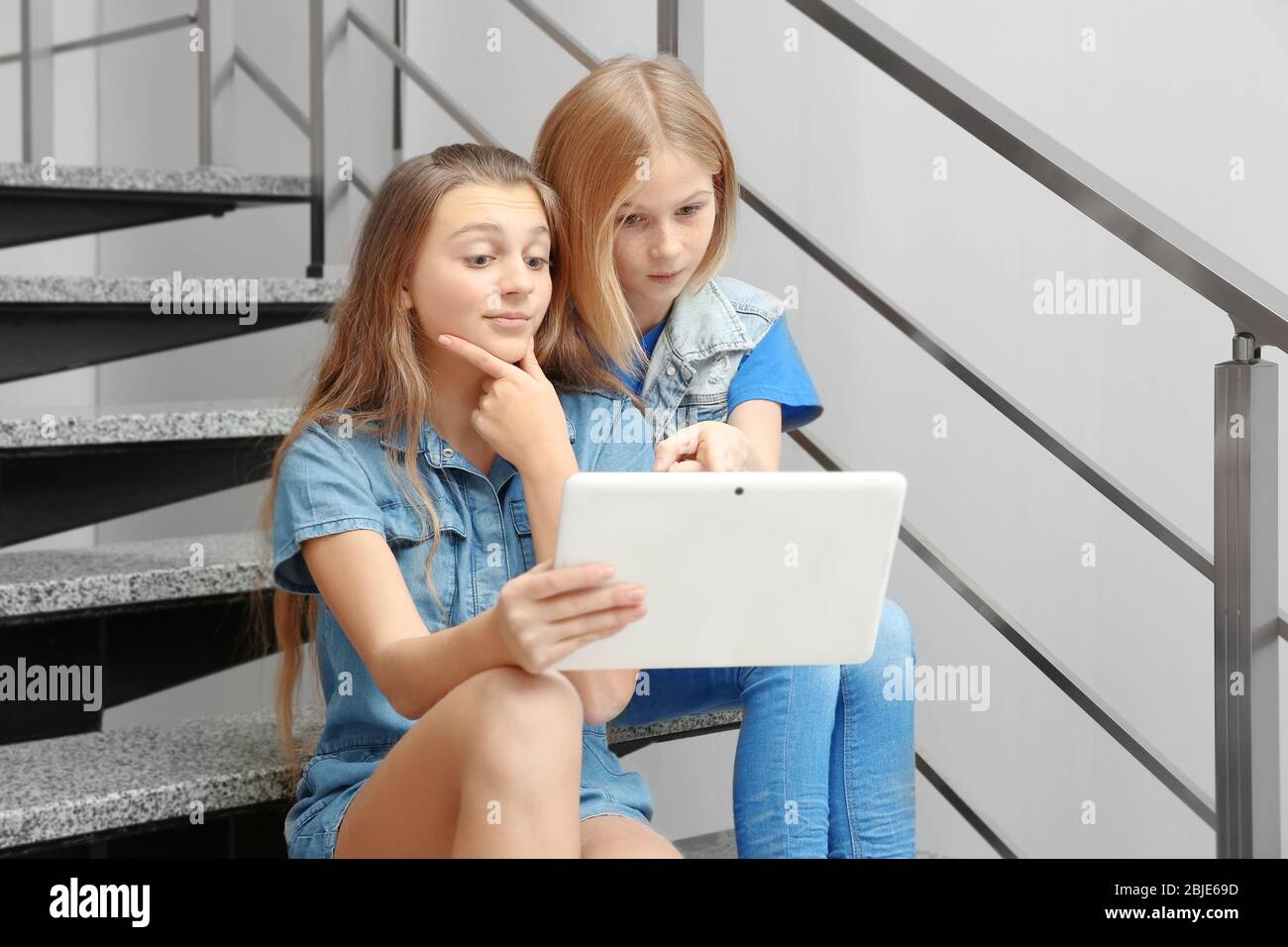 Two girls sitting on stairs hi-res stock photography and images - Alamy