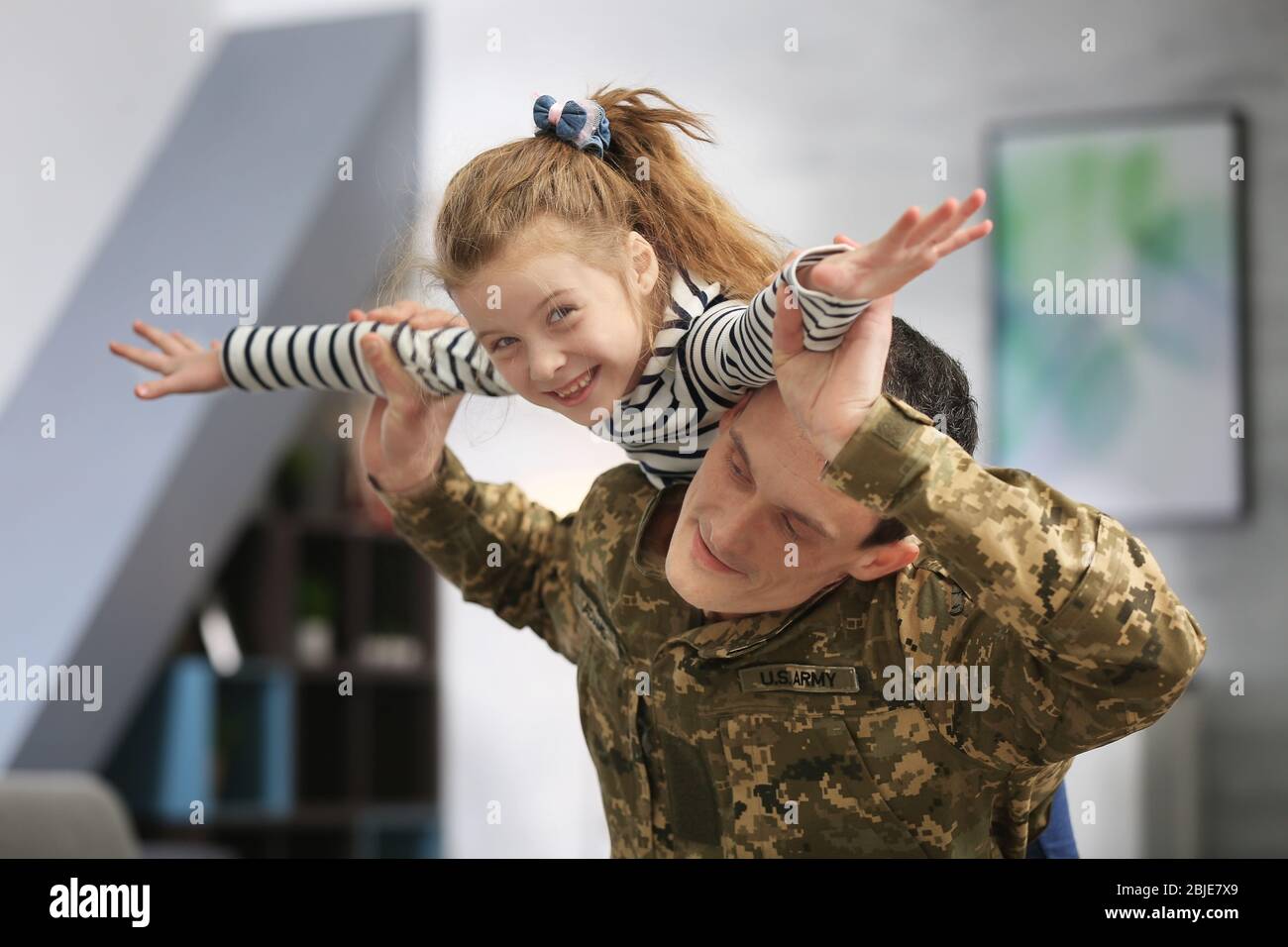 Soldier in camouflage playing with his daughter at home Stock Photo Alamy