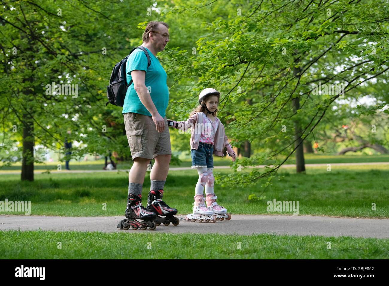 Father and daughter on rollerblades, daily exercise in London Lockdown. Stock Photo