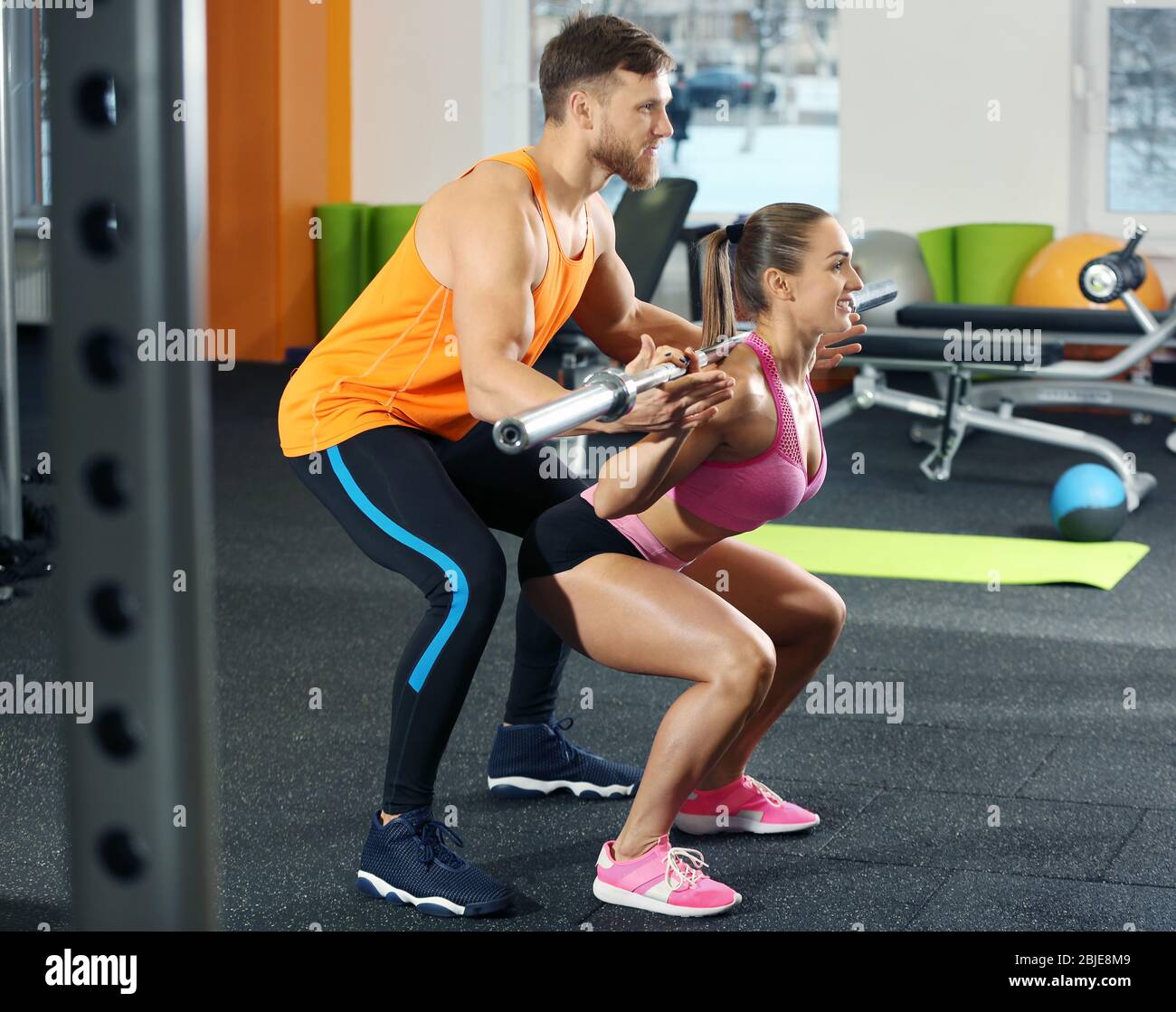 Beautiful sportive woman training with her trainer in gym Stock Photo ...