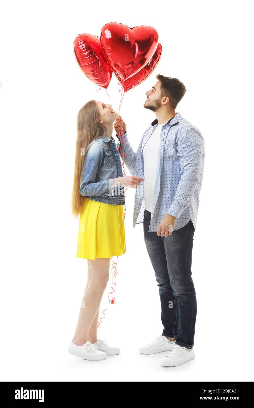 Cute young couple with balloons in shape of hearts on white background ...