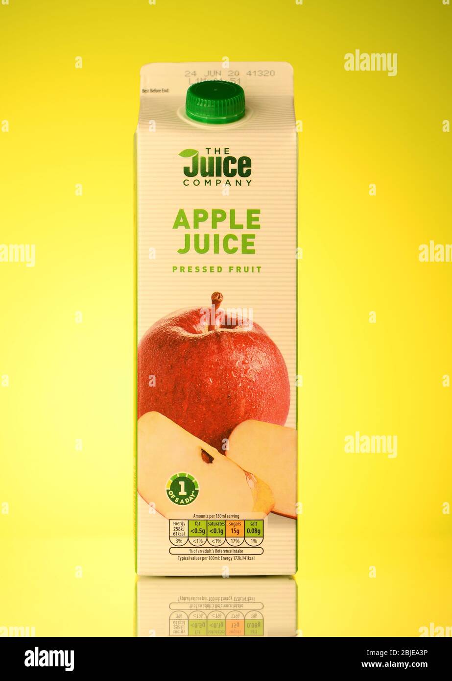 The Juice company Apple juice carton drink isolated on a spring yellow background with reflection. Stock Photo