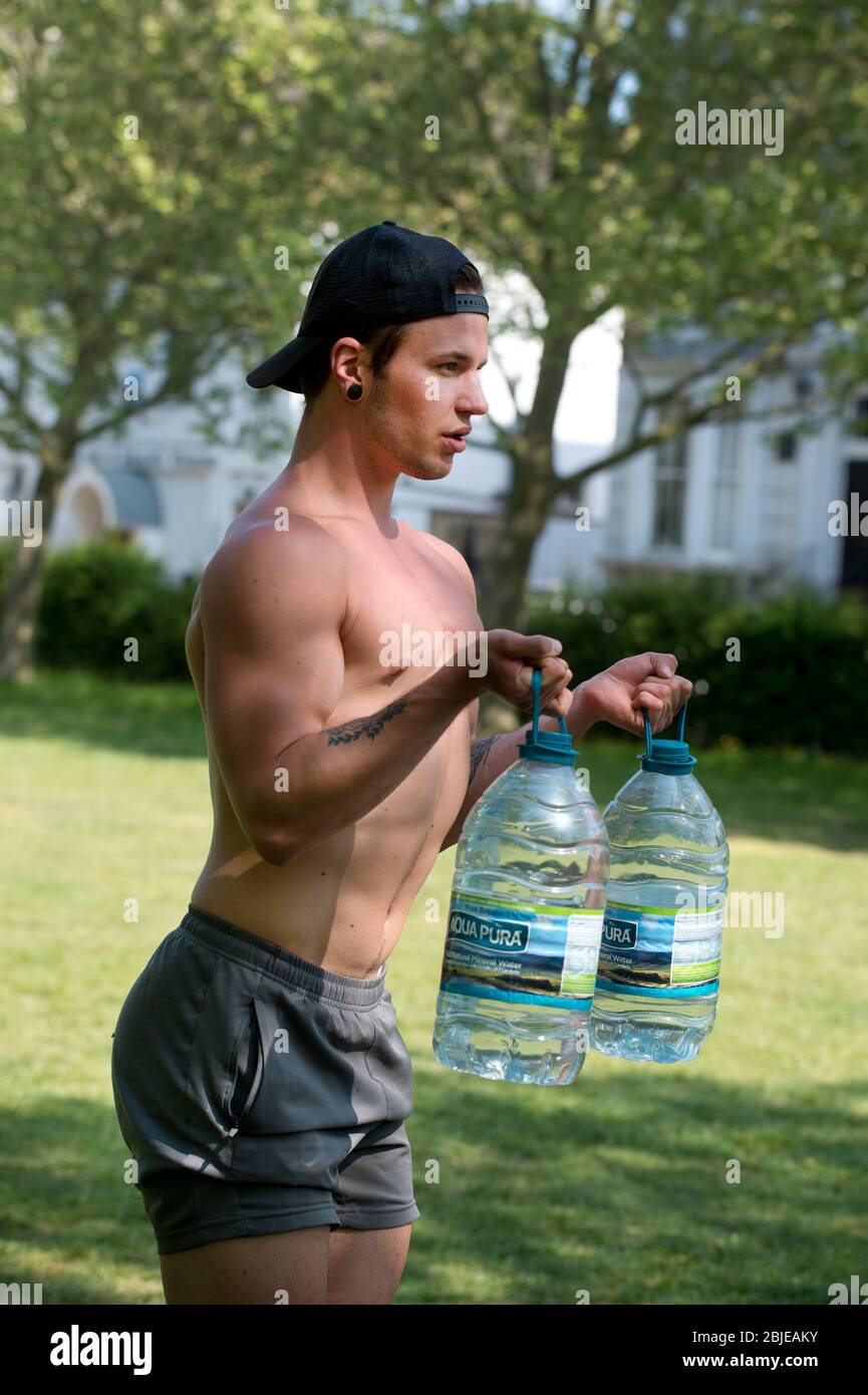 Tower Hamlets, London, UK. Eddy , orignally from Lithuania, trains with bottles of water in the park. Eddie, orignally from Lithuania, exercises with Stock Photo