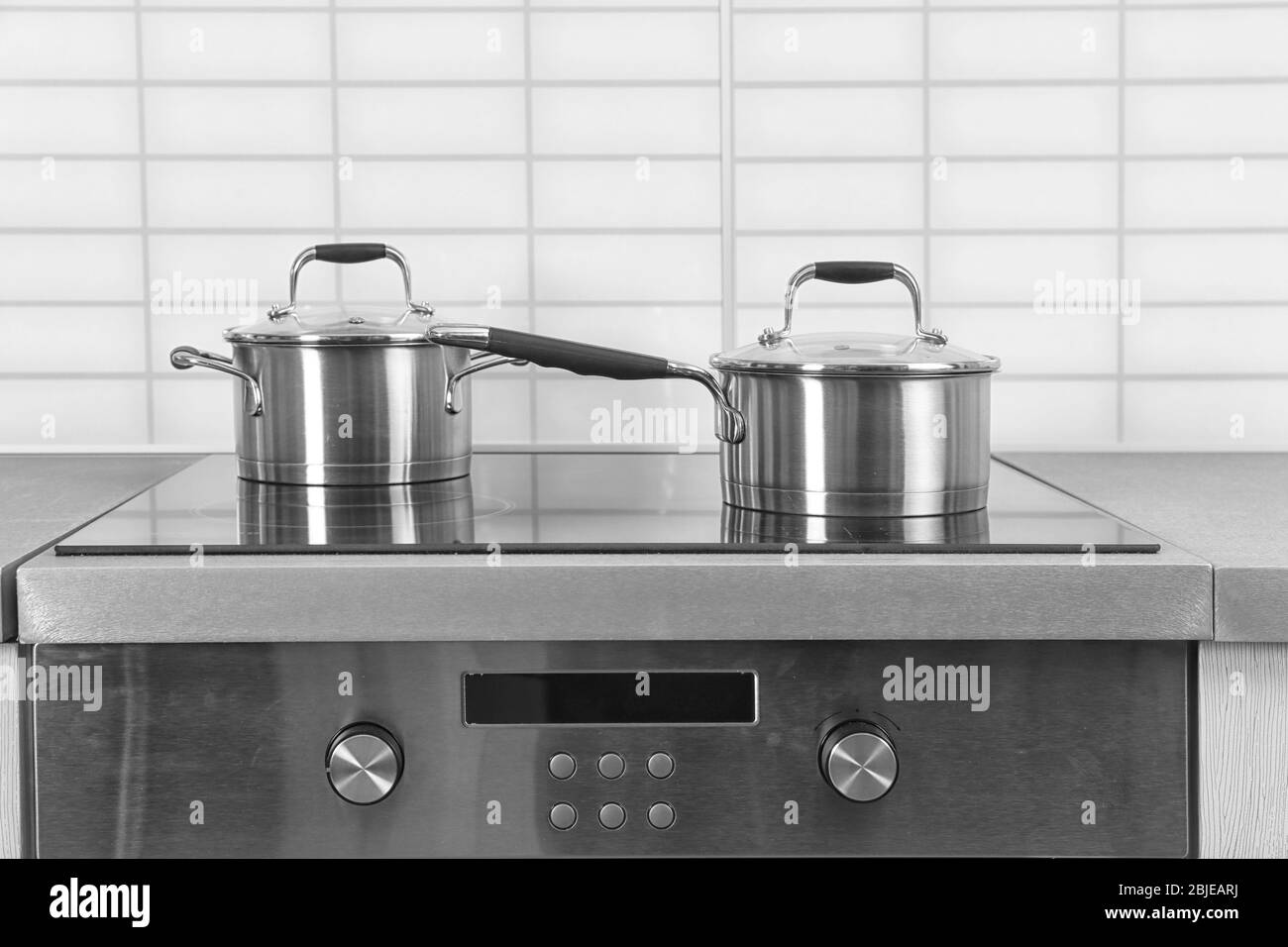 Two saucepans on electric stove in kitchen Stock Photo Alamy