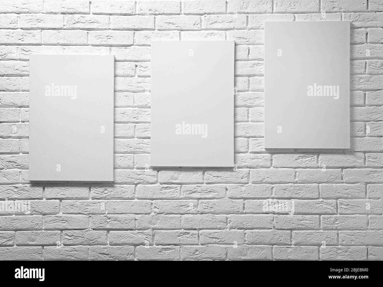 Empty canvases on white brick wall background Stock Photo Alamy