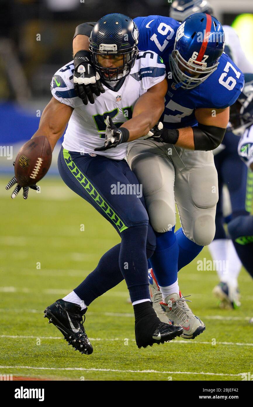 December 15, 2013: Seattle Seahawks middle linebacker Bobby Wagner (54) flips ball as he tries to break free from New York Giants guard Brandon Mosley Stock Photo