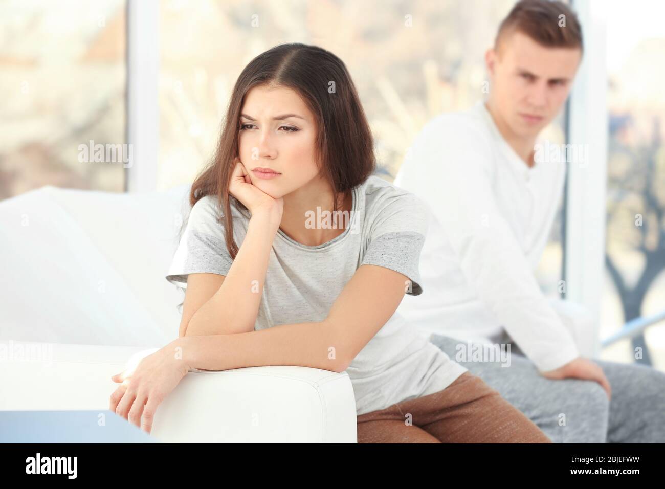 Young woman sitting on sofa after quarrel with boyfriend Stock Photo ...