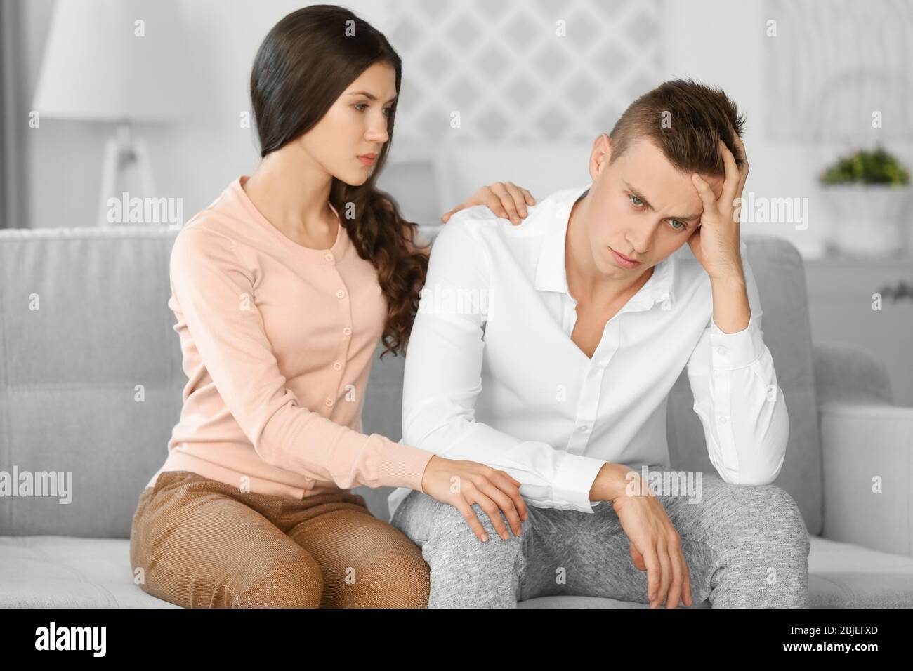 Young depressed man with girlfriend at home Stock Photo Alamy