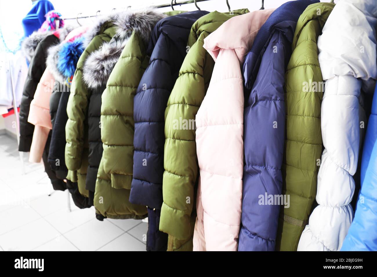 Winter clothes on hangers in modern shop Stock Photo - Alamy