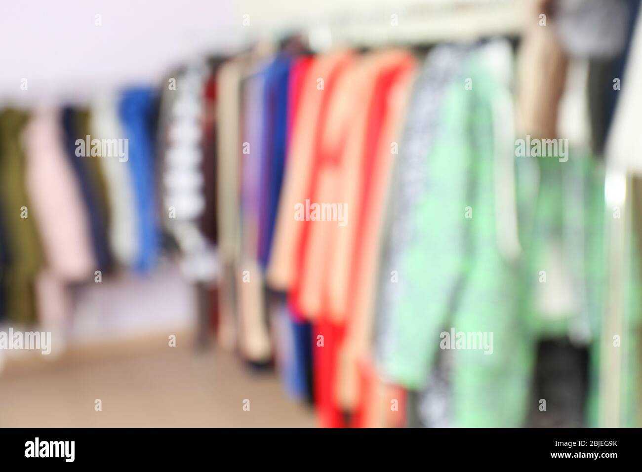 Blurred view of rack with different clothes in modern shop Stock Photo ...