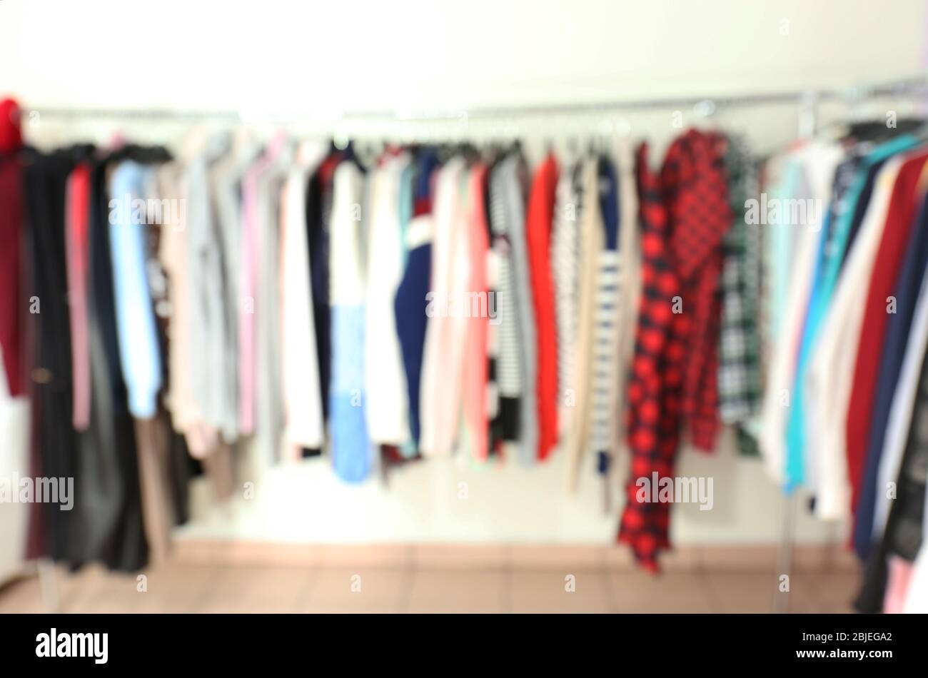 Blurred view of rack with different clothes in modern shop Stock Photo ...
