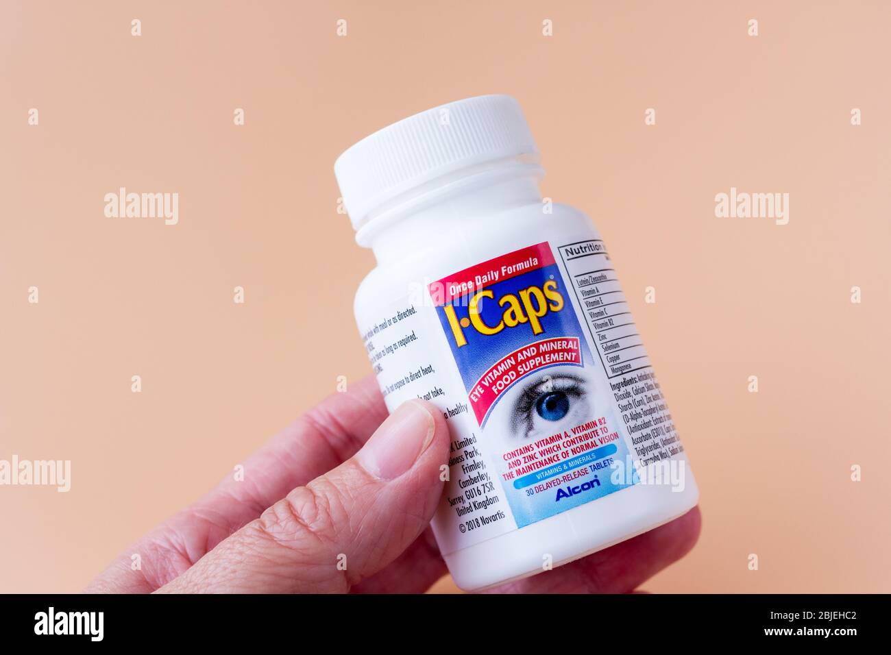 Photograph of Holding a bottle of I-Caps vitamin food supplement tablets for eye health Stock Photo