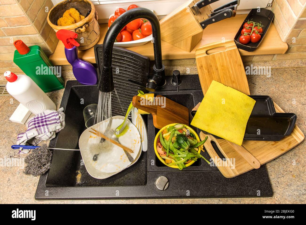 Kitchen sink with dirty dishes. Washing dishes at home. Water consumption.  Black kitchen sink Stock Photo - Alamy