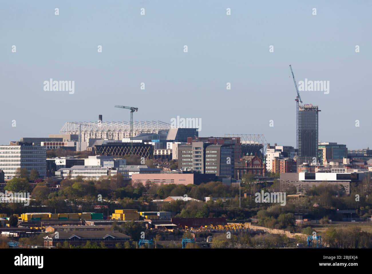 Buildings, including St James' Park and Hadrian's Tower, in Newcastle upon Tyne, England. A crane rises from Hadrian's Tower. Stock Photo